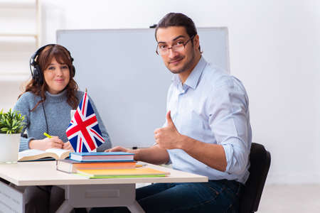 Young female student and male english teacher in the classroomの写真素材