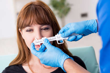 Young beautiful woman visiting doctor in plastic surgery concept