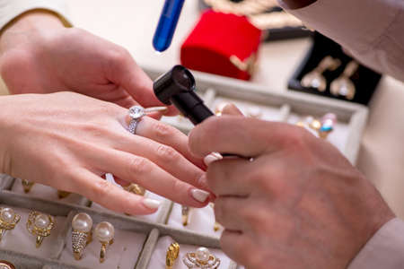 Young woman visiting old male jeweler