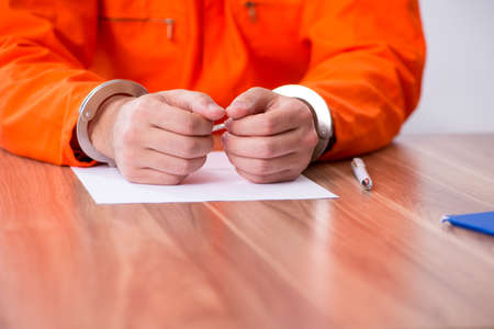 Young man writing letter in provisional detentionの写真素材