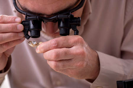 Old male jeweler at workshopの写真素材