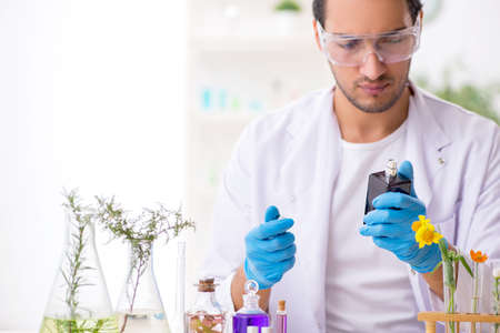 Young male chemist in perfume synthesis concept