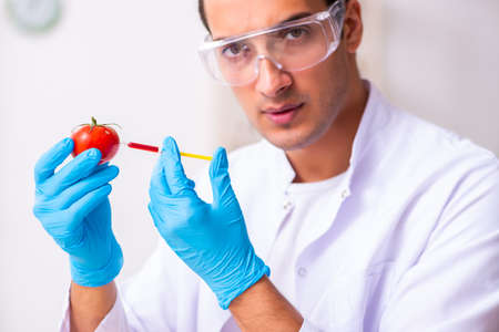 Young male nutrition expert testing food products in labの写真素材