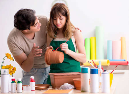 Couple decorating pots in workshop during classの写真素材