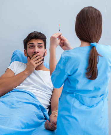 Woman doctor examining male patient in hospitalの写真素材