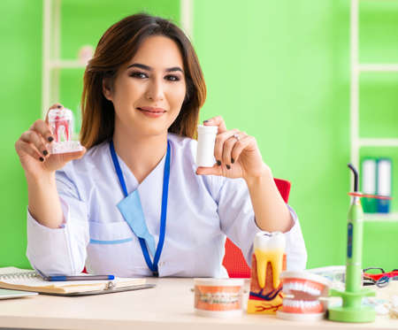 Woman dentist working on teeth implant