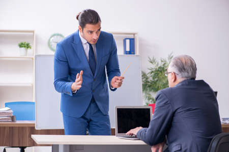Yound and old employees in business presentation conceptの写真素材