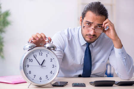 Young male employee in budget planning conceptの写真素材