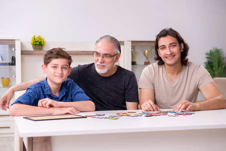 Three generations of family playing jigsaw puzzle game