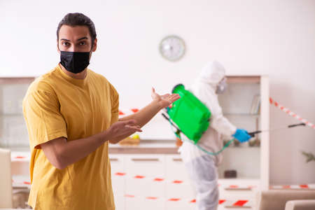 Sanitizer and young man indoors in disinfection conceptの写真素材