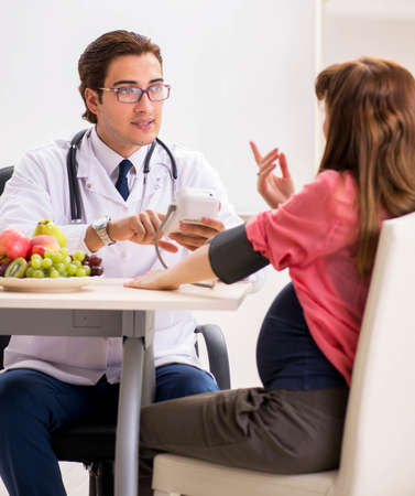 Pregnant woman visiting doctor discussing healthy diet