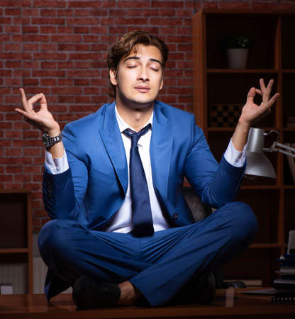 Young businessman working in the office at nightの写真素材