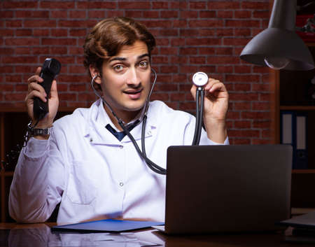 Young handsome doctor working night time at the hospitalの写真素材