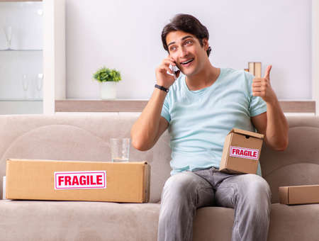 Man opening fragile parcel ordered from internetの写真素材