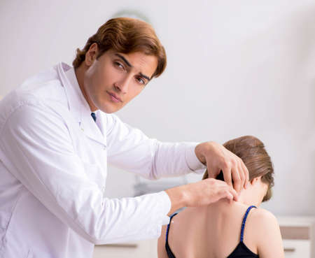 Female patient visiting young handsome doctor chiropractor