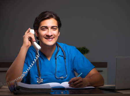 Young handsome doctor working night shift in hospitalの写真素材