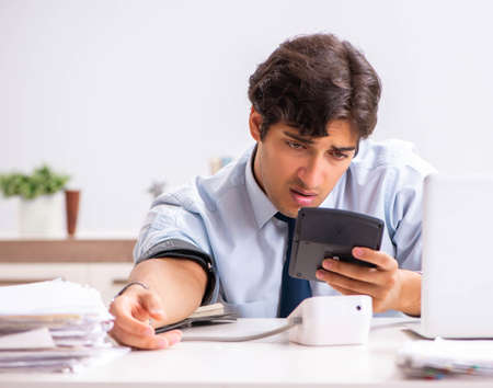 Man under stress measuring his blood pressureの写真素材