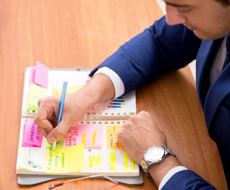 Young handsome employee planning his work activity