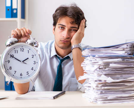 Overloaded busy employee with too much work and paperworkの写真素材