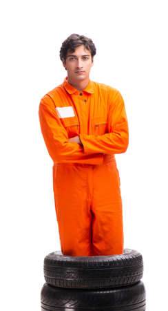 Young garage worker with tyre isolated on whiteの写真素材