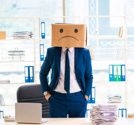 The unhappy man with box instead of his headの写真素材