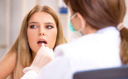 Young beautiful woman visiting female dentistの写真素材