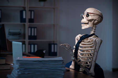 Young male employee working in the office night timeの写真素材