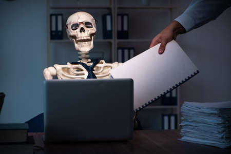 Young employee working in the office night timeの写真素材