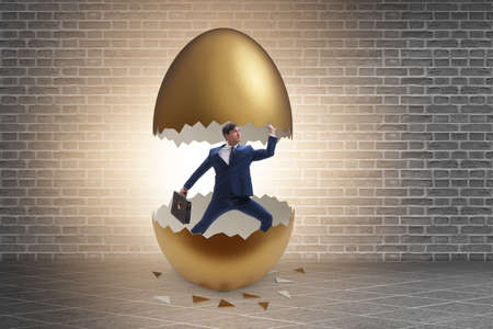 Businessman breaking out of golden egg
