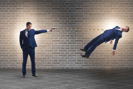 Businessman with gun threatening his competitorの写真素材