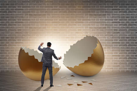 Businessman breaking out of golden eggの写真素材