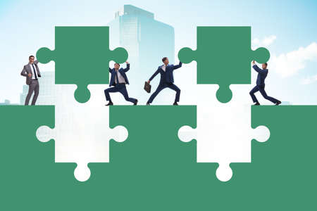 Businessman in teamwork concept with jigsaw puzzleの写真素材