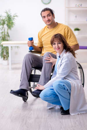 Young male patient in wheel-chair doing physical exercisesの写真素材