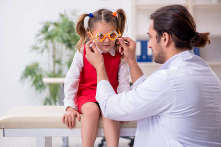 Small girl visiting young male doctor oculistの写真素材