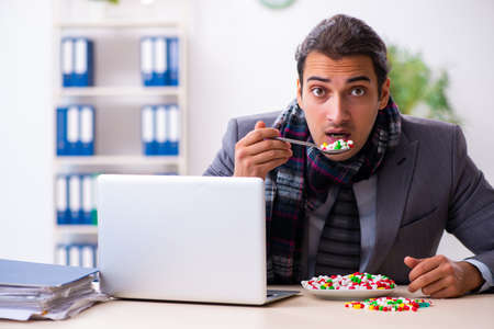 Young male employee suffering at workplaceの写真素材
