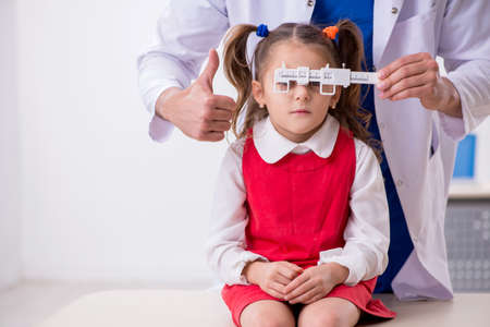 Small girl visiting young male doctor oculistの写真素材