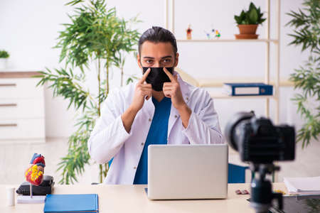 Young male doctor recording video for his blogの写真素材