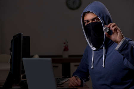 Male hacker hacking security firewall late in office