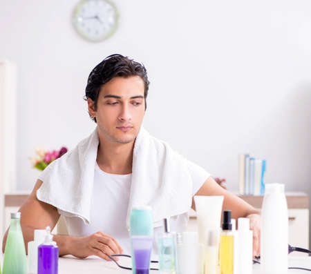 Young handsome man in the bathroom in hygiene conceptの写真素材