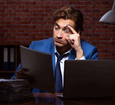 Young businessman working in the office at nightの写真素材