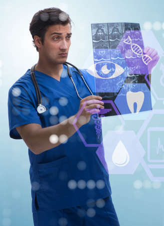 Young doctor looking at x-ray image in mhealth concept