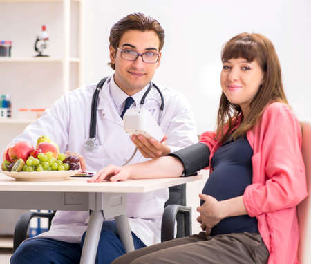 Pregnant woman visiting doctor discussing healthy diet