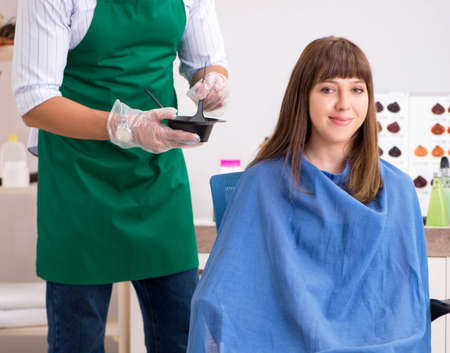 Young woman visiting young handsome barberの写真素材