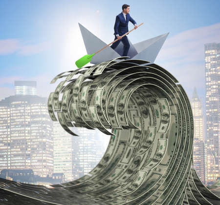 The businessman riding paper boat in dollar seaの写真素材
