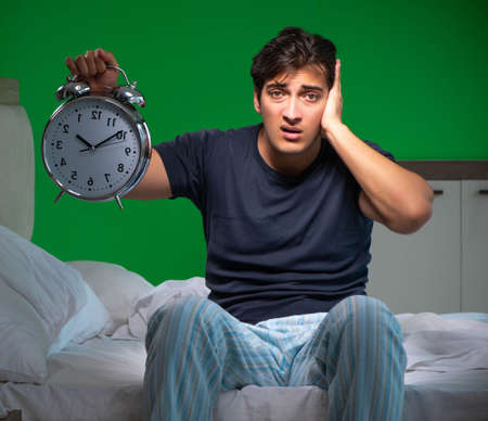 Young handsome man suffering from insomnia at homeの写真素材