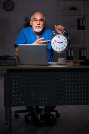 Aged male doctor in the hospital at nightの写真素材