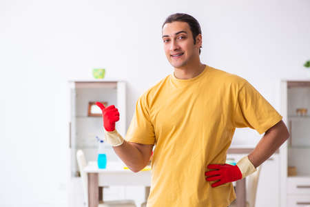 Young male contractor cleaning the houseの写真素材