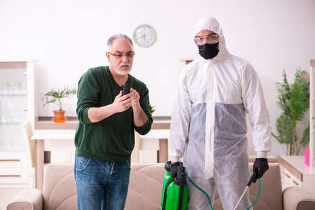 Young male sanitizer and old man indoorsの写真素材