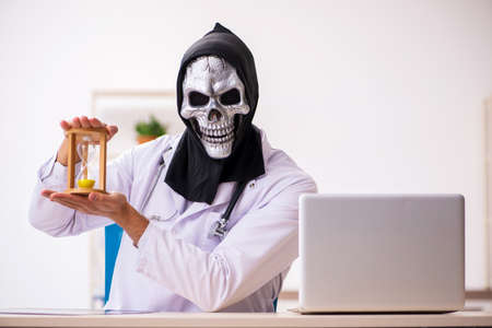 Male devil doctor in time management conceptの写真素材