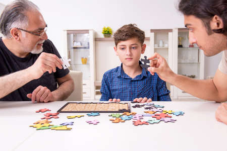 Three generations of family playing jigsaw puzzle game